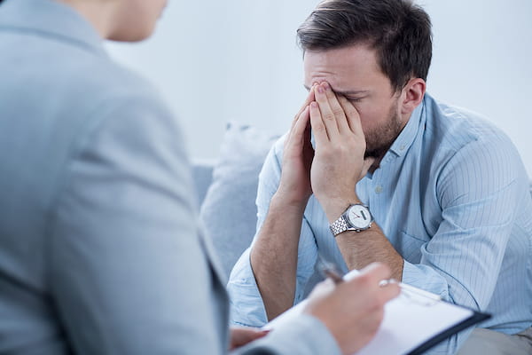 Man crying during psychotherapy session. Dr. Ethan Bregman offers comprehensive psychotherapy services for adults and adolescents facing a wide range of life challenges.